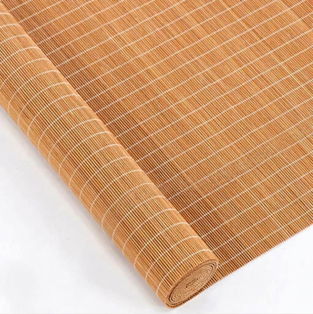 Close-up of rolled woven bamboo shade material and connecting threads